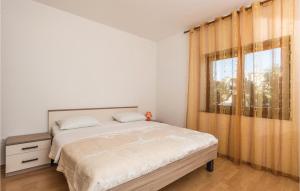 a bedroom with a large bed and a window at Beautiful Apartment In Povljana in Povljana