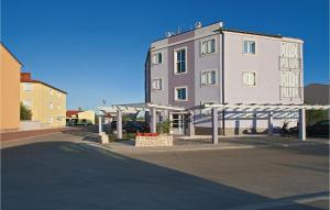 un grand bâtiment blanc avec un parking en face de celui-ci dans l'établissement Apartment Vodnjan Peroj Iii, à Vodnjan