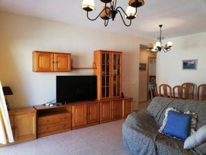 a living room with a couch and a flat screen tv at Delfines III Solo Familias Serviplaya in Playa de Xeraco