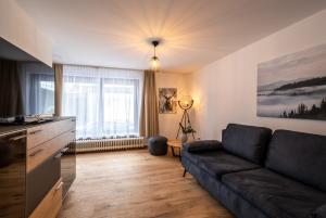 sala de estar con sofá y ventana grande en Bergzeit Appartments en Bad Gastein