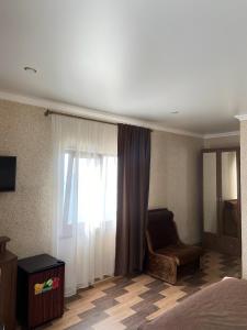 1 dormitorio con cama, ventana y silla en Apra en Lidzava