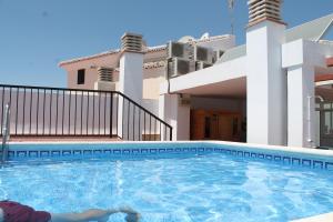 a woman laying in a swimming pool in front of a house at Apartamentos Turísticos Plaza del Olvido in Nerja