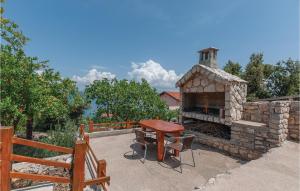 patio con tavolo e camino in pietra di 2 Bedroom Gorgeous Apartment In Raslina a Raslina
