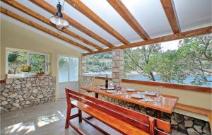 une salle à manger avec un banc et une grande fenêtre dans l'établissement Gorgeous Home In Vela Luka With House Sea View, à Vela Luka