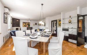 une salle à manger avec une table et des chaises blanches dans l'établissement 4 Bedroom Gorgeous Home In Jurdani, à Jurdani