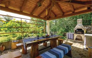un patio al aire libre con mesa y chimenea en Beautiful Home In Jurdani With Wifi, en Jurdani
