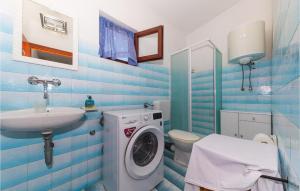 ein Badezimmer mit einer Waschmaschine und einem Waschbecken in der Unterkunft Beautiful Apartment In Vinisce With Outdoor Swimming Pool in Vinišće