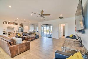 a living room with two couches and a kitchen at Phoenix Home with Desert Views and Garden-Style Yard in Anthem