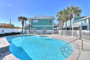 una piscina frente a una casa con palmeras en Aqua Meridian MC12, en Port Aransas