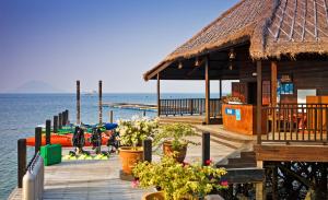 un quai en bois avec un bâtiment sur l'eau dans l'établissement Gayana Marine Resort, à Île de Gaya