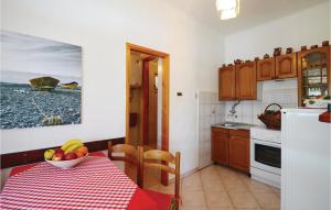 a kitchen with a table with a bowl of fruit on it at Pet Friendly Home In Trget With House Sea View in Trget
