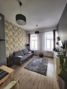 uma sala de estar com um sofá e uma mesa em Pokoje przy Arkadii em Suwałki