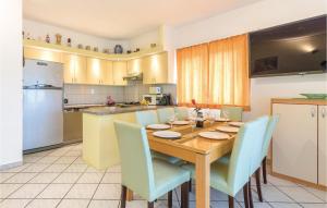 a kitchen with a wooden table and blue chairs at 4 Bedroom Beautiful Apartment In Stinjan in Štinjan