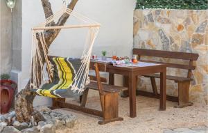 a hammock and a wooden table and a chair at Stunning Home In Makarska With 1 Bedrooms And Wifi in Makarska