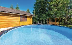 duży basen obok drewnianego budynku w obiekcie 2 Bedroom Nice Home In Trosmarija w mieście Trošmarija