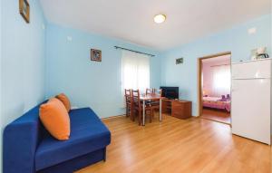 Gorgeous Home In Novigrad With Kitchen في نوفيغراد دالماتيا: غرفة معيشة زرقاء مع أريكة زرقاء وطاولة