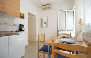 a kitchen and dining room with a table and chairs at Stunning Apartment In Raslina With 1 Bedrooms And Wifi in Raslina
