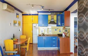a kitchen with blue and yellow cabinets and a table at Stunning Apartment In Brela With Wifi in Brela