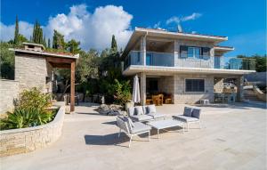 契利比的住宿－Beautiful Apartment In Cilipi With Outdoor Swimming Pool，一个带椅子的庭院和一座房子