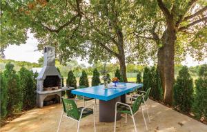 a blue table and chairs with a fireplace on a patio at 2 Bedroom Gorgeous Apartment In Valtursko Polje in Pula