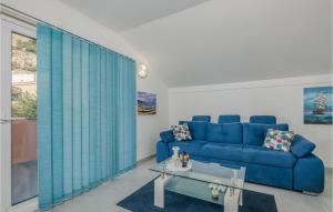 a living room with a blue couch and a table at Awesome Apartment In Stara Baska in Stara Baška