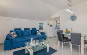 uma sala de estar com um sofá azul e uma mesa em Nice Apartment In Stara Baska With Kitchen em Stara Baška