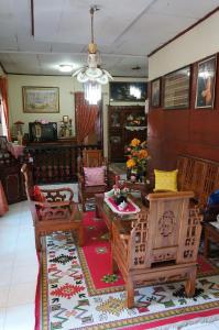 a living room with wooden chairs and a table at Cendana Homestay in Sawahlunto