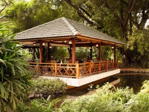 a gazebo in a garden next to a pond at The Oberoi Bengaluru in Bengaluru