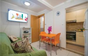 ein Wohnzimmer mit einem Tisch und einem TV an der Wand in der Unterkunft Gorgeous Apartment In Stari Grad With Kitchen in Stari Grad