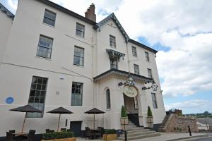 a large building with a clock on the front of it at Royal Hotel by Greene King Inns in Ross on Wye