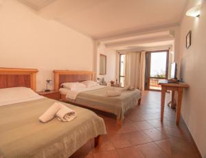 a hotel room with two beds and a balcony at Apartments and Rooms Levantin Inn in Sveti Stefan