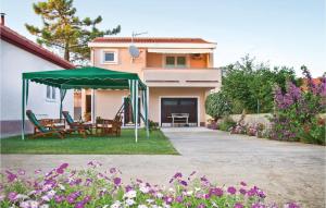 a house with a green umbrella in the yard at Awesome Home In Privlaka With 2 Bedrooms And Wifi in Privlaka