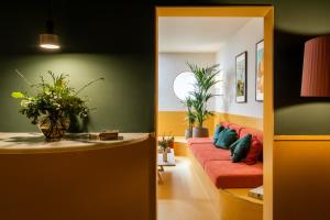 sala de estar con sofá rojo y paredes verdes en BYPILLOW Mothern en Barcelona