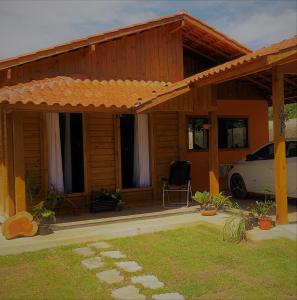 una casa con un coche aparcado delante de ella en Pousada Portal da Praia, en Anchieta