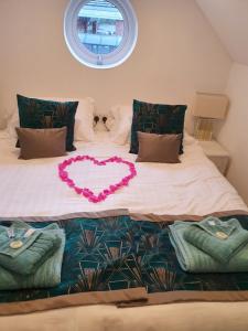 Una cama con un corazón hecho en ella en The Wheatsheaf Inn en Atherstone