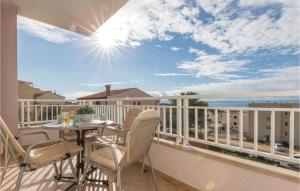 a balcony with a table and chairs and a view of the ocean at Apartment Vukovarska Iv in Makarska