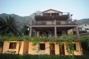 une maison avec un balcon au-dessus dans l'établissement Bjelica Apartments Kotor, à Kotor