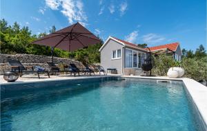 ein Pool mit Sonnenschirm und Stühlen und ein Haus in der Unterkunft 1 Bedroom Beautiful Home In Blato in Blato