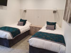 two beds in a small room withskirts at The Wheatsheaf Inn in Atherstone