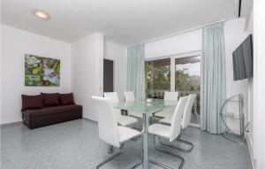 a dining room with a glass table and white chairs at Nice Apartment In Stinjan With Kitchen in Štinjan
