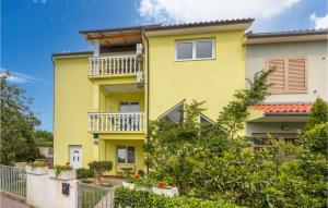 a yellow apartment building with a balcony at Nice Apartment In Stinjan With Kitchen in Štinjan