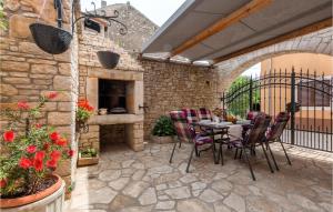 a patio with a table and chairs and a fireplace at Awesome Apartment In Vodnjan With Wifi in Vodnjan