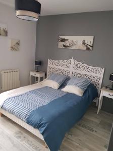 1 dormitorio con 1 cama con manta azul en Fée Morgane - Chambres, en Saint-Coulomb