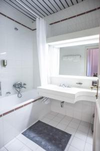 a white bathroom with a sink and a mirror at Belladonna Panorama Apartment in Bad Gastein