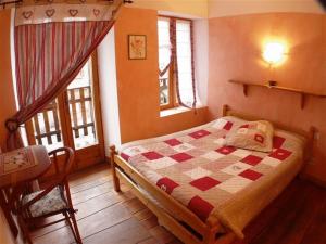 a bedroom with a bed with a checkered quilt at La Ptite Auberge in Aiguilles