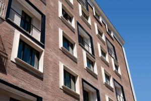 a tall red brick building with many windows at Noba Hotel e Residenze in Rome