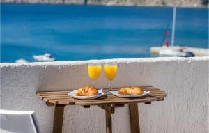 a table with two glasses of orange juice and croissants at 2 Bedroom Gorgeous Home In Baska in Baška