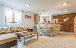 a living room with a couch and a stone fireplace at Amazing Apartment In Orbanici With Kitchen in Orbanići