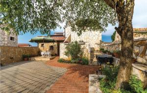 a house with a brick driveway and a tree at Amazing Apartment In Orbanici With Kitchen in Orbanići