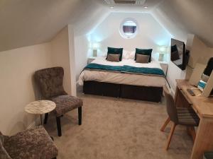 a bedroom with a bed and a desk and a chair at The Wheatsheaf Inn in Atherstone